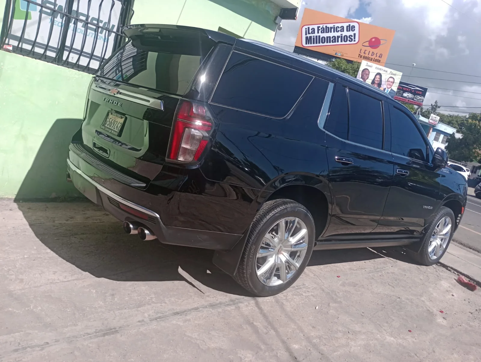 Vista trasera lateral junto a edificio verde — Chevrolet Tahoe · Unidad B